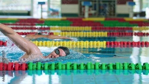 Slow motion of two female swimmers during a race in the freestyle swim discipline, slow motion shot. Concept of front crawl stroke technique.
