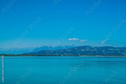 Germany, Bodensee lake constance view to swiss coast green mountains summit mountain saentis summer blue sky and sun panorama