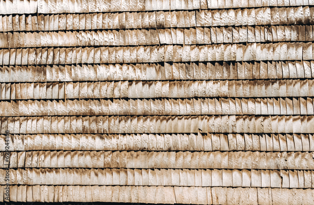 Wooden shingles. Natural roof material of rustic style. Abstract background. Brown and gray color. Old rooftop. Wall facade in village style. Wood pattern. Original surface plank cover Wooden shingles. Natural roof material of rustic style. Abstract background. Brown and gray color. Old rooftop. Wall facade in village style. Wood pattern. Original surface plank cover