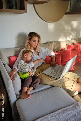 Mother and son watching film on laptop together