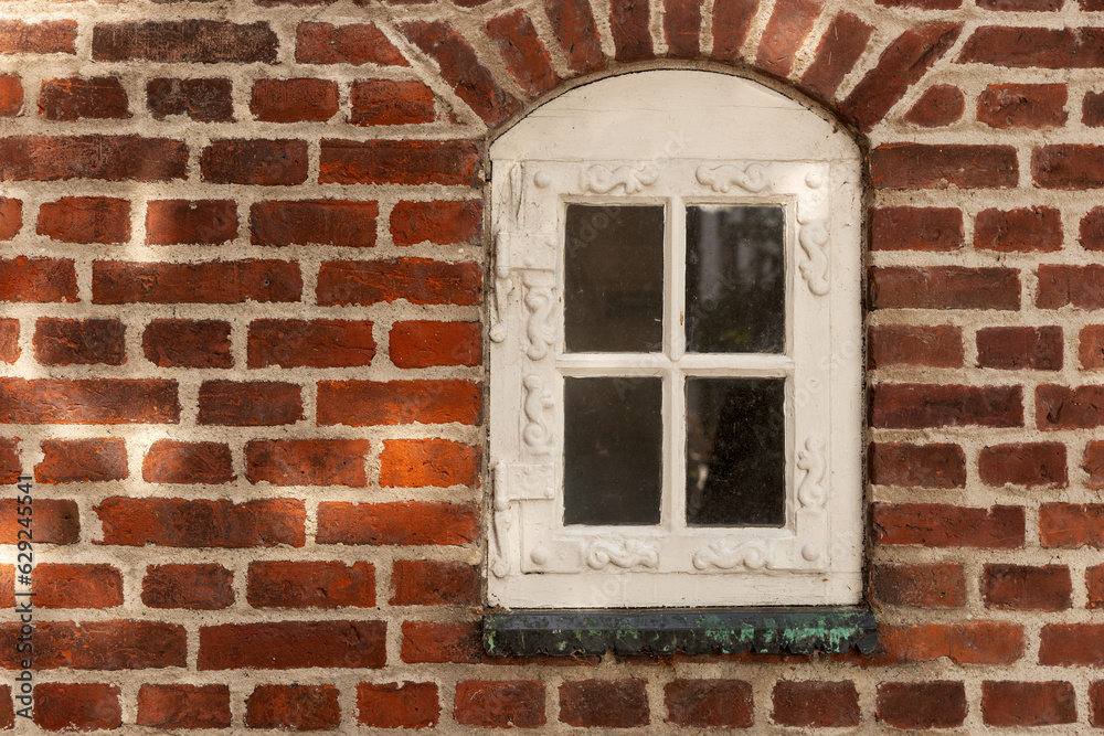 Red brick wall with white arched window