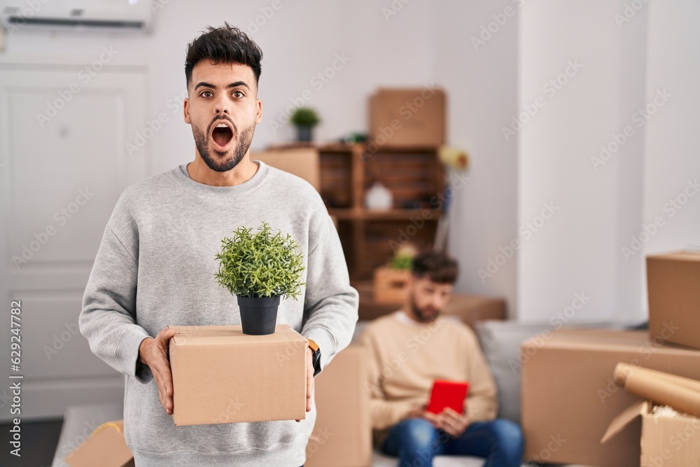 Homosexual couple moving to a new home afraid and shocked with surprise and amazed expression, fear and excited face. Homosexual couple moving to a new home afraid and shocked with surprise and amazed expression, fear and excited face.