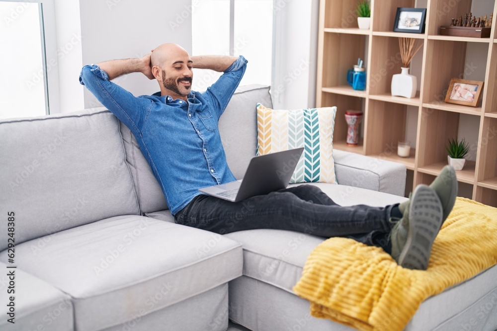 Young hispanic man relaxed with hands on head using laptop at home Young hispanic man relaxed with hands on head using laptop at home