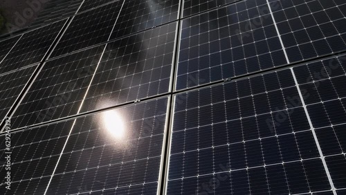 Over mirroring sunlight collectors on a house roof, summer evening  - Aerial view