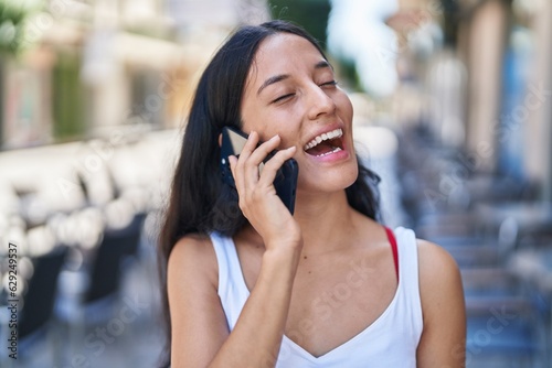 Young beautiful hispanic woman smiling confident talking on the smartphone at street