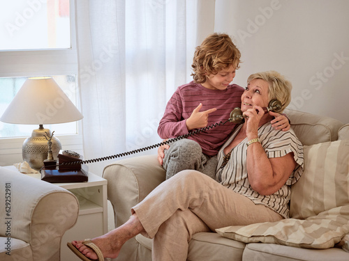 Grandmother talking on telephone near boy