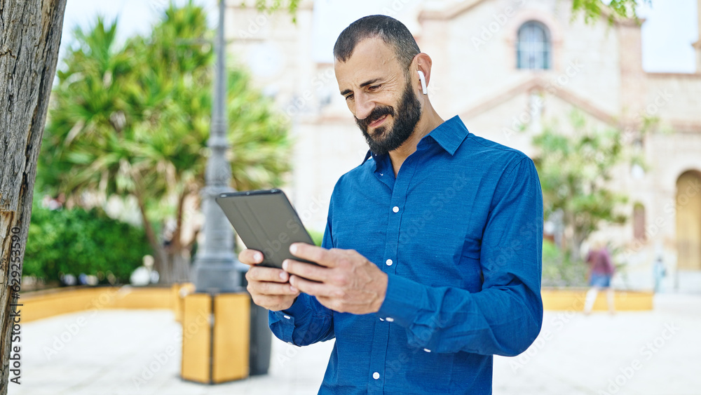 Young hispanic man smiling confident watching video on touchpad at park Young hispanic man smiling confident watching video on touchpad at park