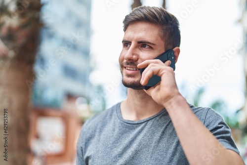 Young caucasian man smiling confident talking on the smartphone at street