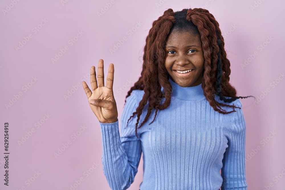 African woman standing over pink background showing and pointing up with fingers number four while smiling confident and happy. African woman standing over pink background showing and pointing up with fingers number four while smiling confident and happy.