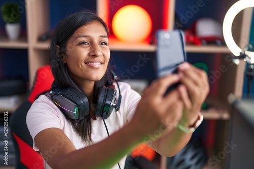 Young beautiful hispanic woman streamer smiling confident make selfie by smartphone at street
