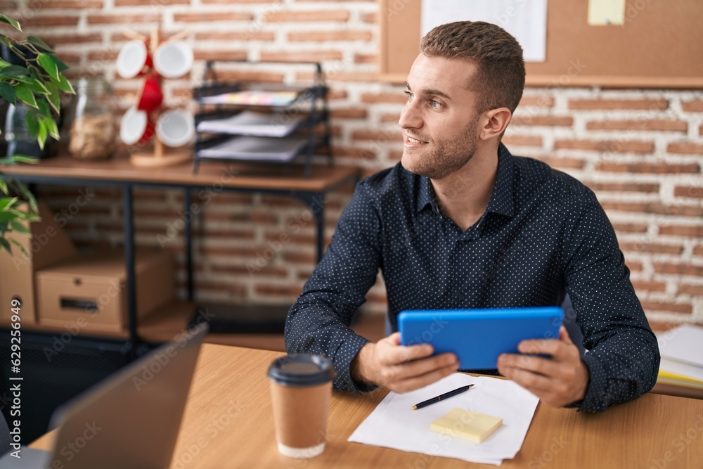 Young caucasian man business worker using touchpad working at office Young caucasian man business worker using touchpad working at office