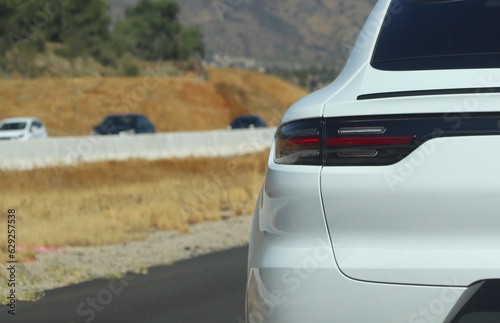 White luxury SUV driving on the highway. 