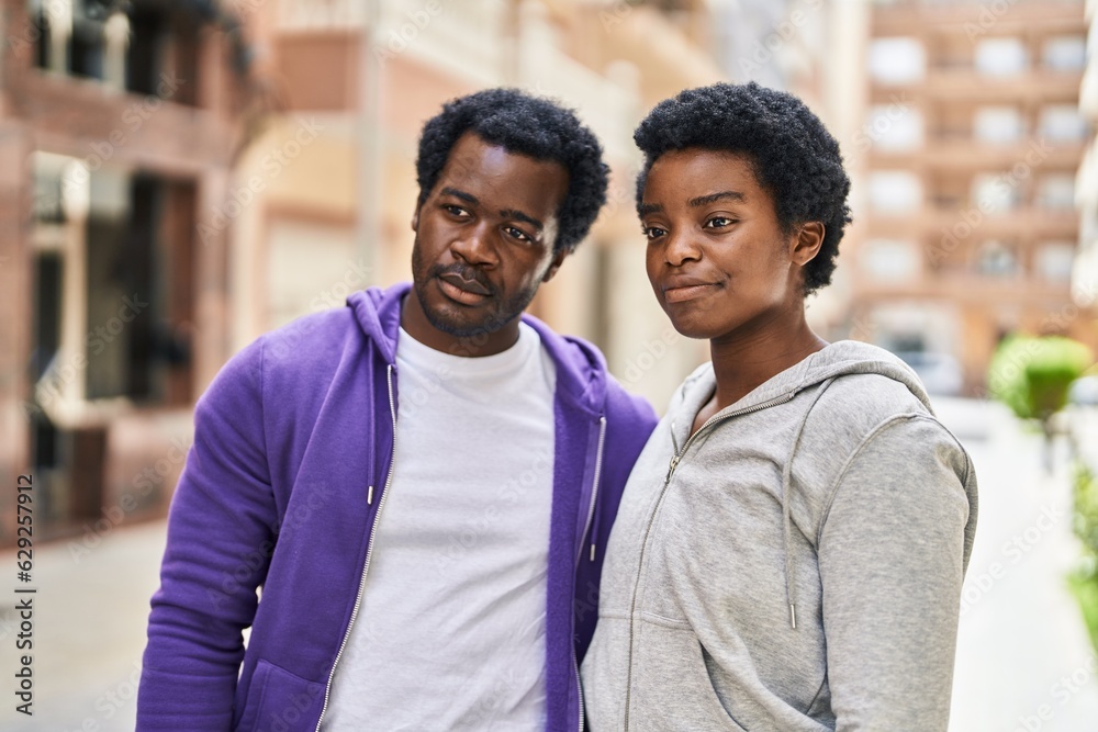 African american man and woman couple standing with relaxed expression at street African american man and woman couple standing with relaxed expression at street