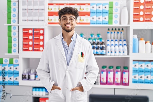 Young arab man pharmacist smiling confident standing at pharmacy