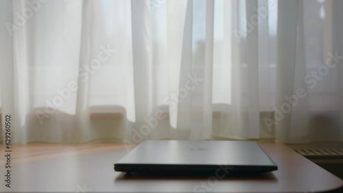 Man hand typing on phone then put it down and closes laptop.