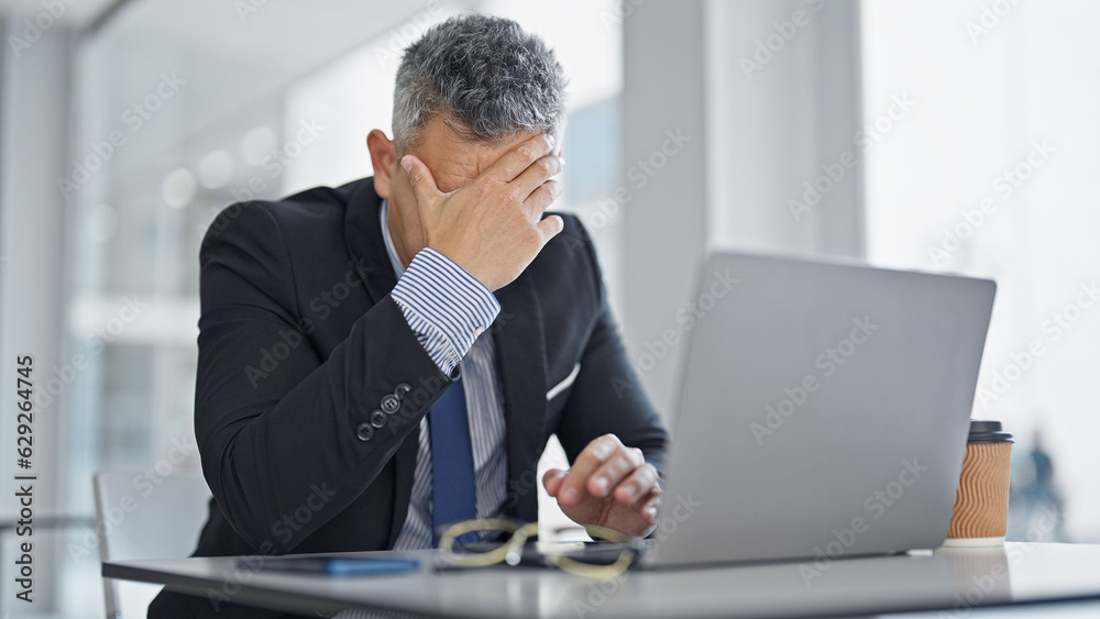 Young hispanic man business worker using laptop stressed at office Young hispanic man business worker using laptop stressed at office