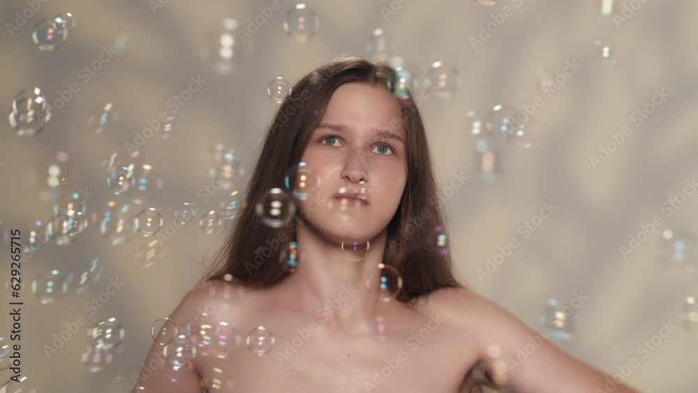 Appealing caucasian girl distracted and annoyed by soap bubbles. Slow motion Appealing caucasian girl distracted and annoyed by soap bubbles. Slow motion