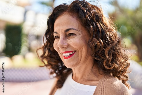 Middle age hispanic woman smiling happy outdoors