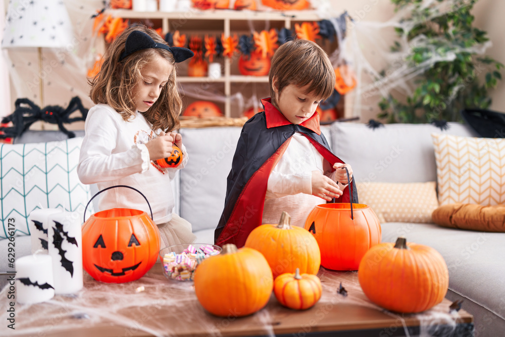 Fototapeta premium Adorable boy and girl having halloween party standing at home