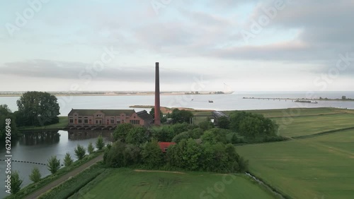 Aerial of the Wouda pumping station in Lemmer, Netherlands alongside the sea and the green field photo