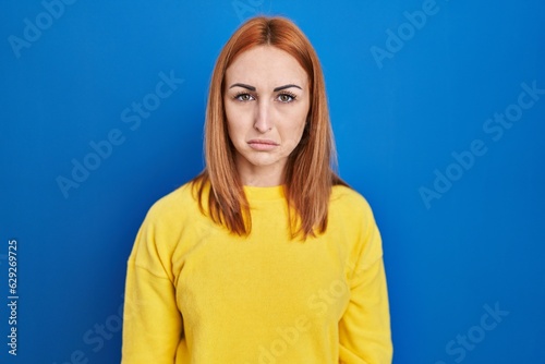 Young woman standing over blue background depressed and worry for distress, crying angry and afraid. sad expression.