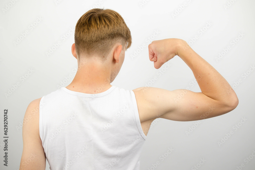 Teenage boy flexing from behind Teenage boy flexing from behind