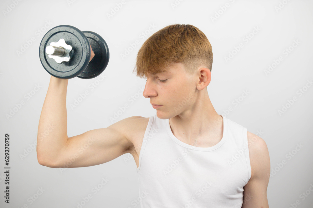 Teenage boy lifting a dumbbell Teenage boy lifting a dumbbell