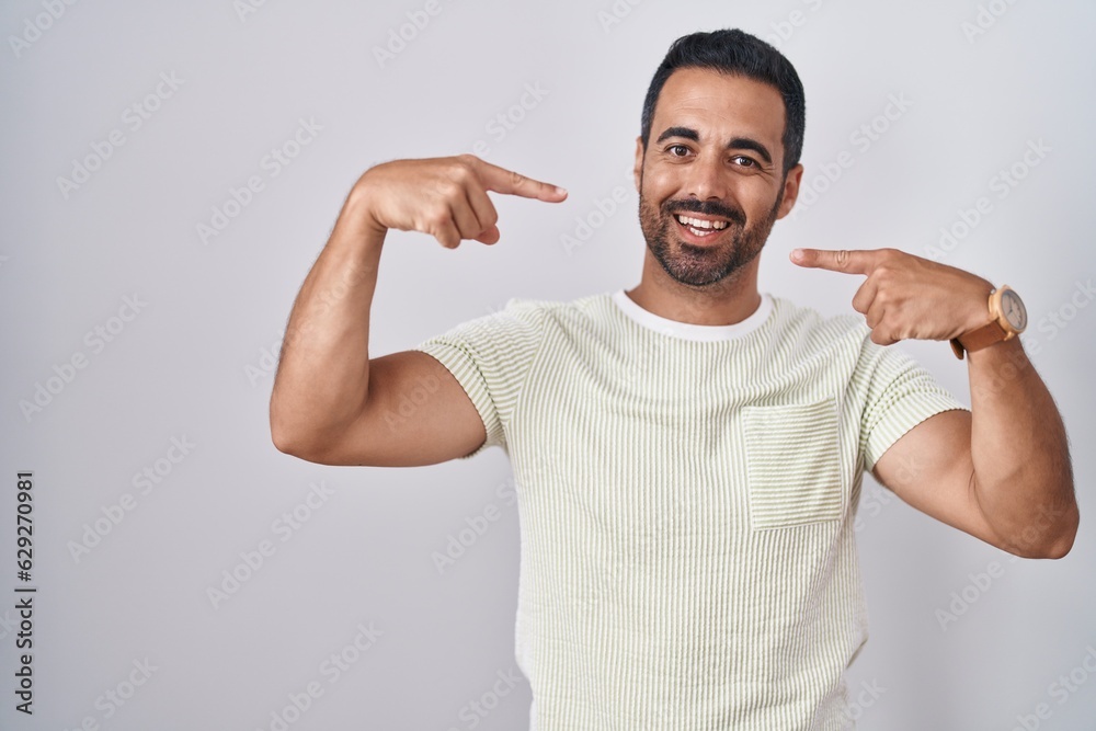 Hispanic man with beard standing over isolated background smiling cheerful showing and pointing with fingers teeth and mouth. dental health concept. Hispanic man with beard standing over isolated background smiling cheerful showing and pointing with fingers teeth and mouth. dental health concept.