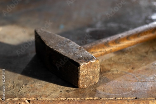 Closeup of a vintage rustic hammer on a metallic table in a garage