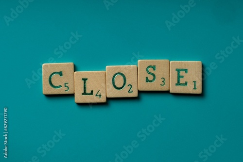 Wooden letters spelling the word "close" on a blue background