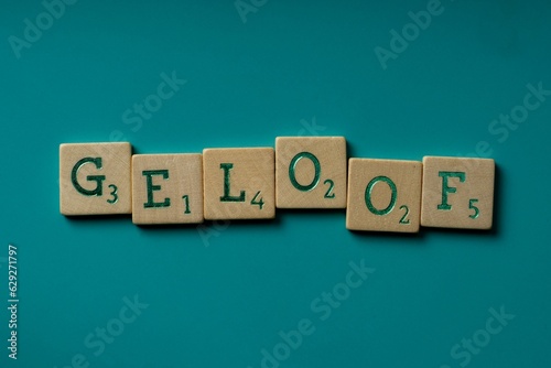 Wooden letters spelling the word Geloof (dutch for faith) on a blue background.