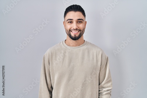 Young handsome man standing over isolated background with a happy and cool smile on face. lucky person.