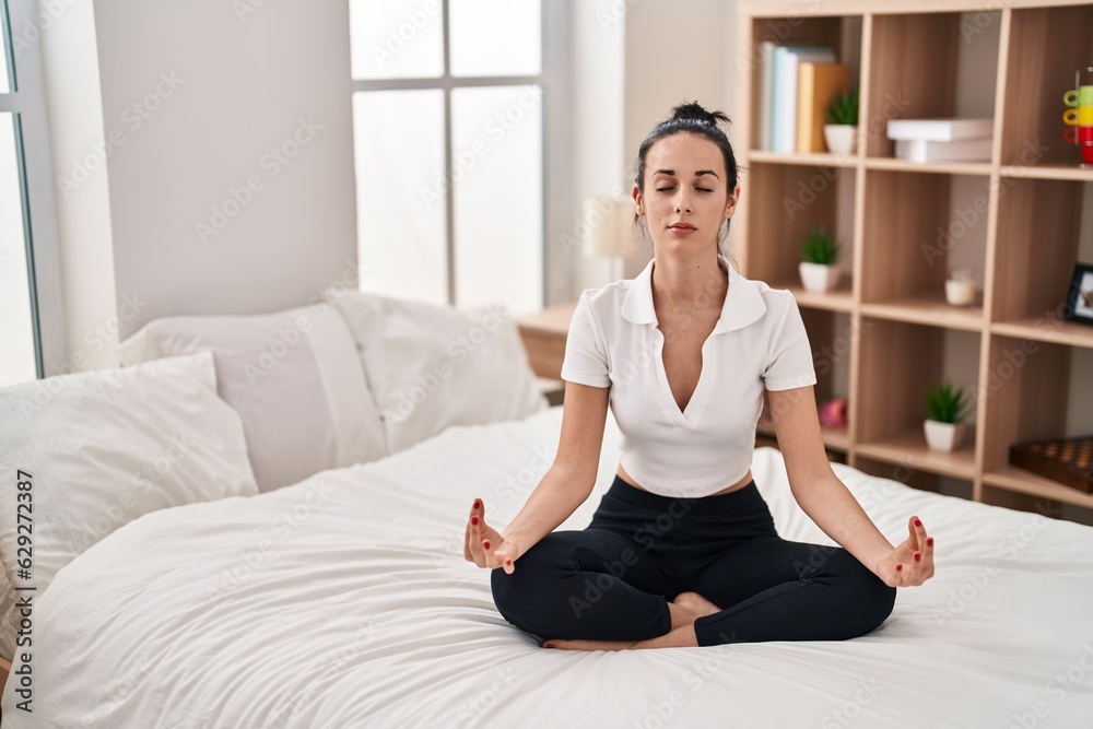 Young caucasian woman doing yoga exercise sitting on bed at bedroom Young caucasian woman doing yoga exercise sitting on bed at bedroom