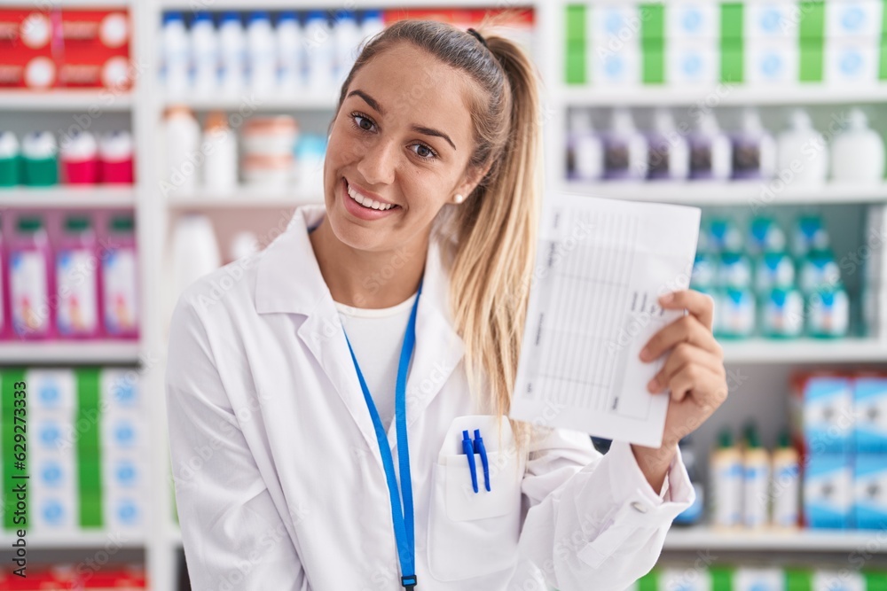 Young beautiful hispanic woman pharmacist smiling confident holding prescription paper at pharmacy