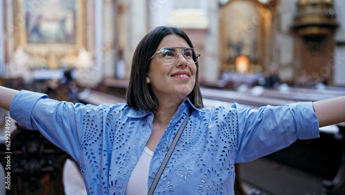 Canvas Print Young beautiful hispanic woman visiting church with open arms at St