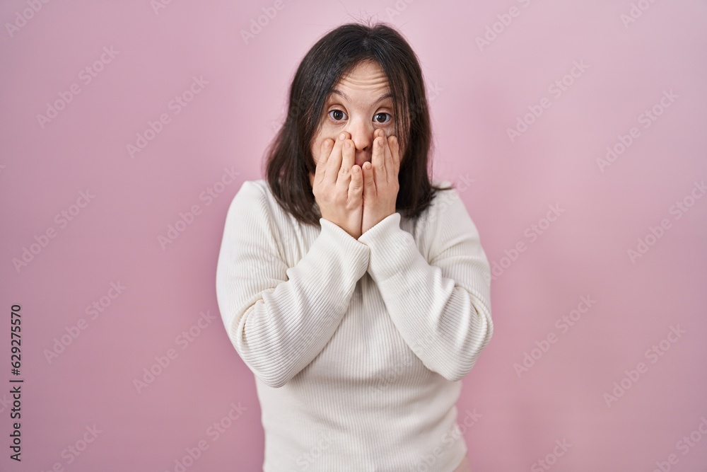 Woman with down syndrome standing over pink background afraid and shocked, surprise and amazed expression with hands on face Woman with down syndrome standing over pink background afraid and shocked, surprise and amazed expression with hands on face