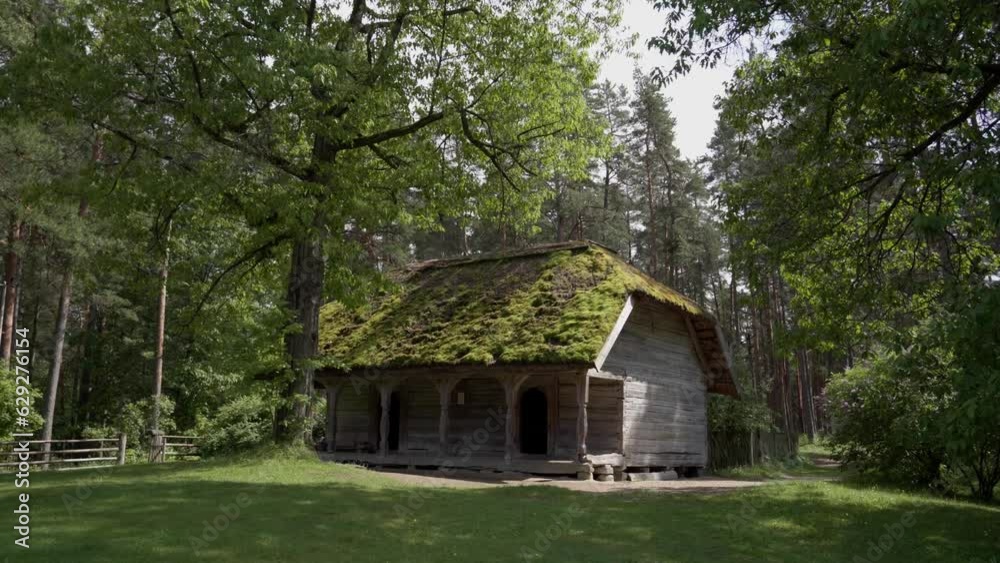 Riga Beautiful Baltic City, and old wood house in the forest in summer. Many years ago the people used to live in this kind of houses, now you can visit this village and travel to the past in Latvia Riga Beautiful Baltic City, and old wood house in the forest in summer. Many years ago the people used to live in this kind of houses, now you can visit this village and travel to the past in Latvia
