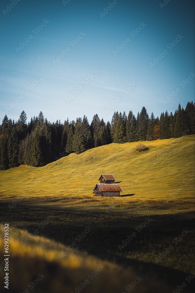 A vertical shot of a Beautiful wooden sheds in Austrian alps