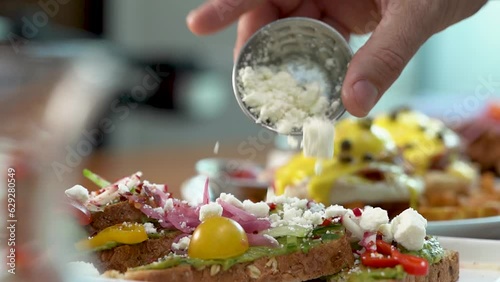 Slow-motion view of a hand adding cottage cheese to a dish