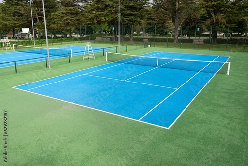 Blue Tennis court on a public park © Andres Victorero/Wirestock Creators
