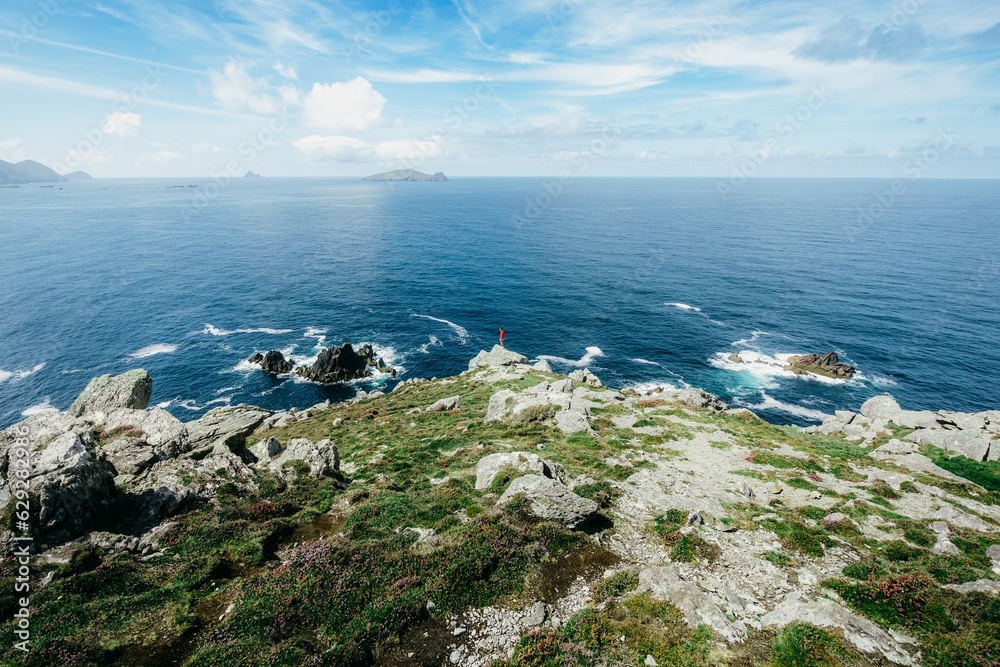 Man standing at the edge of shoreline looking into distance. Man standing at the edge of shoreline looking into distance.