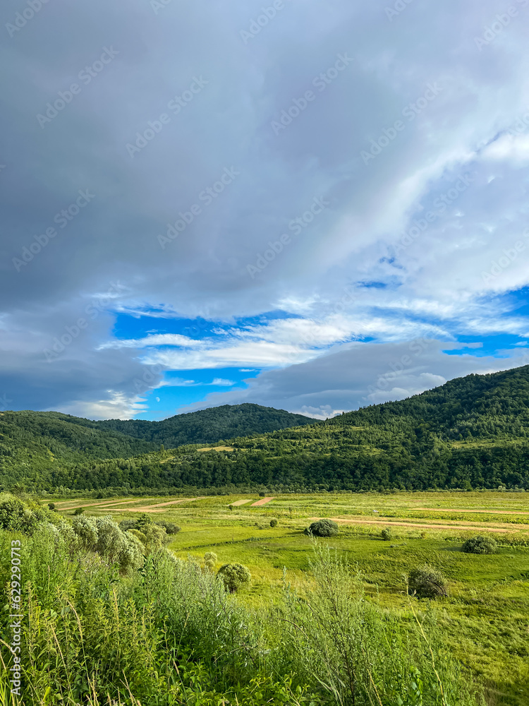 Awesome Carpathian mountains landscape background with forest and clouds on the summer season