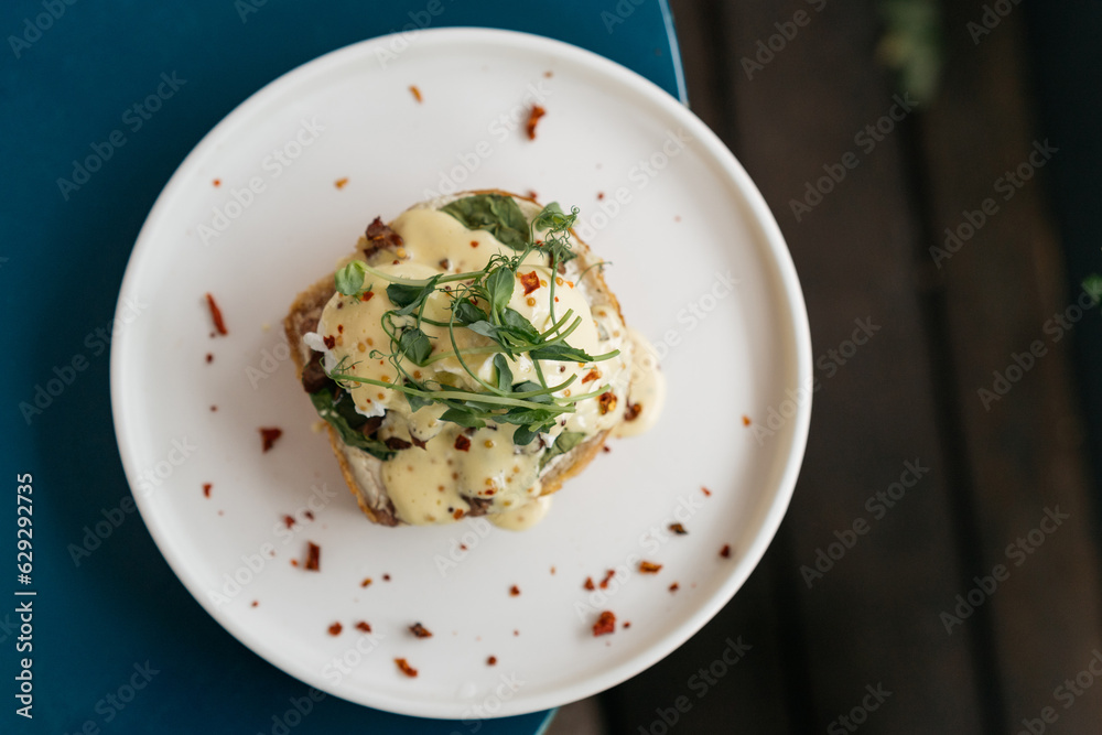 Coffee and toast with eggs benedict with roast beef and hollandaise sauce. Delicious breakfast top view. Coffee and toast with eggs benedict with roast beef and hollandaise sauce. Delicious breakfast top view.