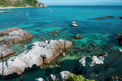 Italy, July 2023: view of the spectacular and relaxing Grotticelle beach near Capo Vaticano in Calabria. You notice the rocks and the bathers having fun during their vacation photo