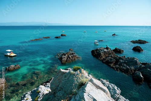 Italy, July 2023: view of the spectacular and relaxing Grotticelle beach near Capo Vaticano in Calabria. You notice the rocks and the bathers having fun during their vacation photo