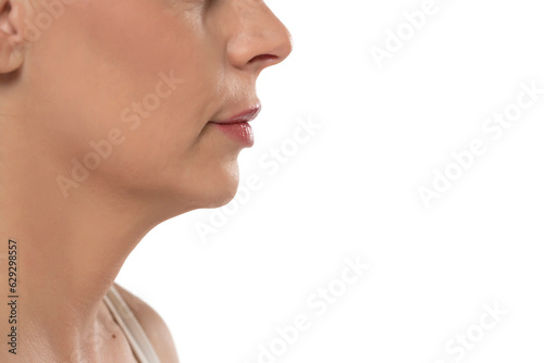 Closeup profile of a middle aged woman's face, mouth, nose and cheek on a white background