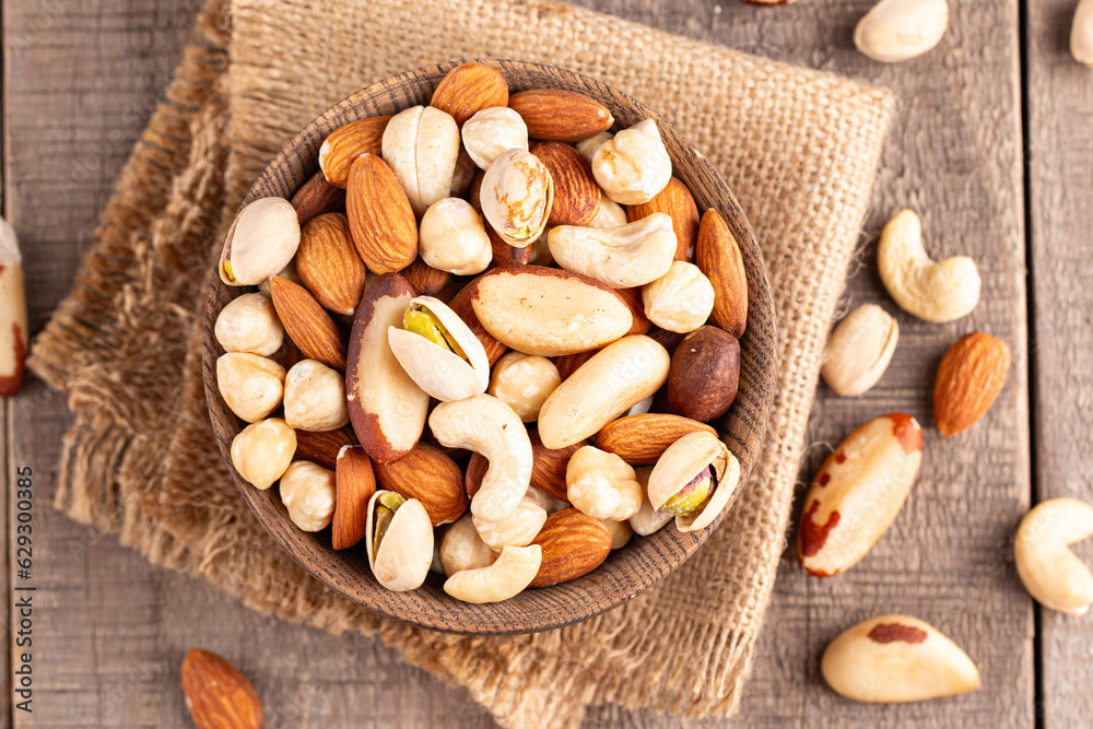 Healthy mix nuts on wooden background. Almonds, hazelnuts, cashews, peanuts, pistachios, Brazilian nuts Healthy mix nuts on wooden background. Almonds, hazelnuts, cashews, peanuts, pistachios, Brazilian nuts