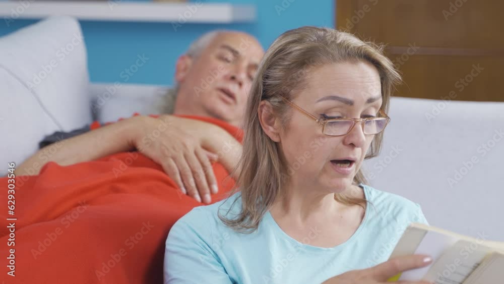A woman reading a book to her husband. Happy couple. A woman reading a book to her husband. Happy couple.