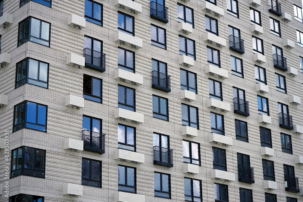 Facade of a modern residential building with many windows.