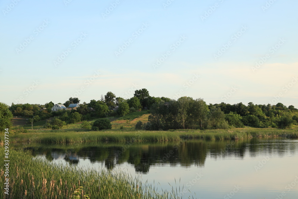 Beautiful lake, green reeds, hill and blue sky Beautiful lake, green reeds, hill and blue sky